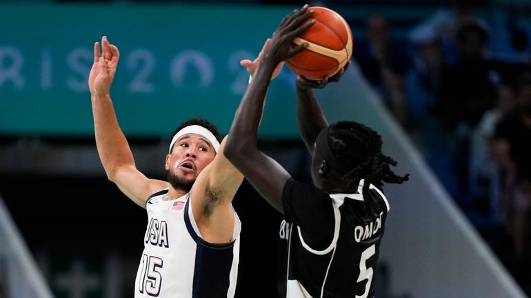 Nuni Omot, of South Sudan, shoots over Devin Booker, of...