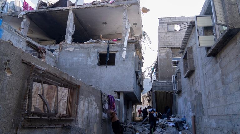 Palestinians inspect a damaged building following Israeli airstrikes on the...