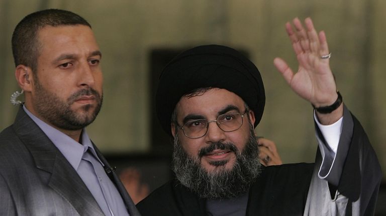 Hezbollah leader Sayyed Hassan Nasrallah, right, escorted by his bodyguard...