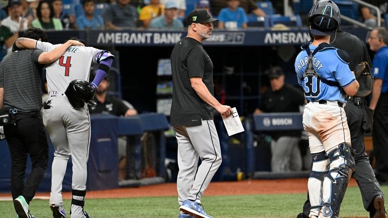 Arizona Diamondbacks manager Torey Lovullo, center, makes a substitution as...