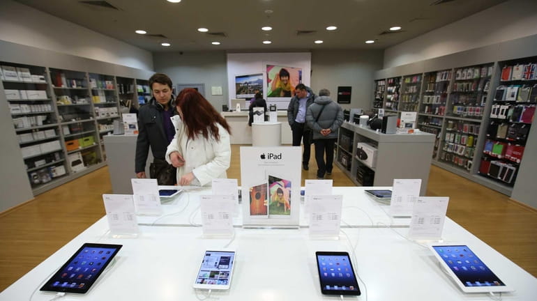 Customers inspect Apple Inc. iPad and iPad mini tablets on...