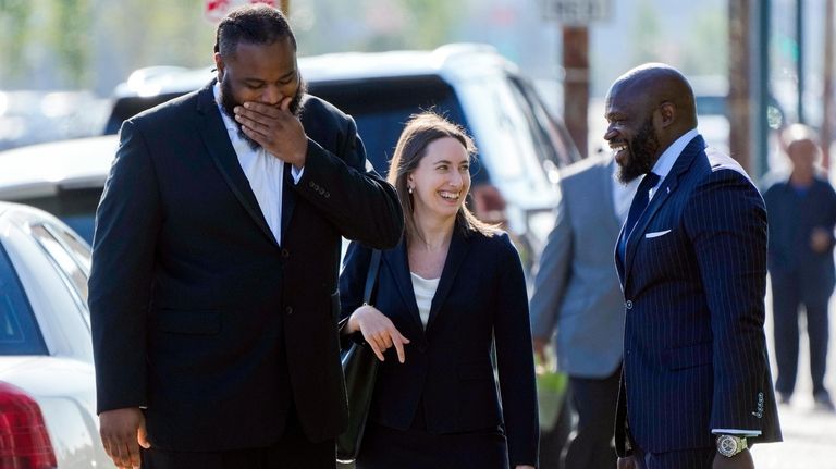 Cardell Hayes, left, is greeted by his defense attorneys John...