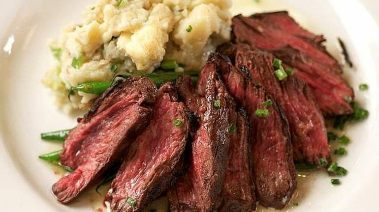 Grilled hanger steak is served with Camembert mashed potatoes, French...