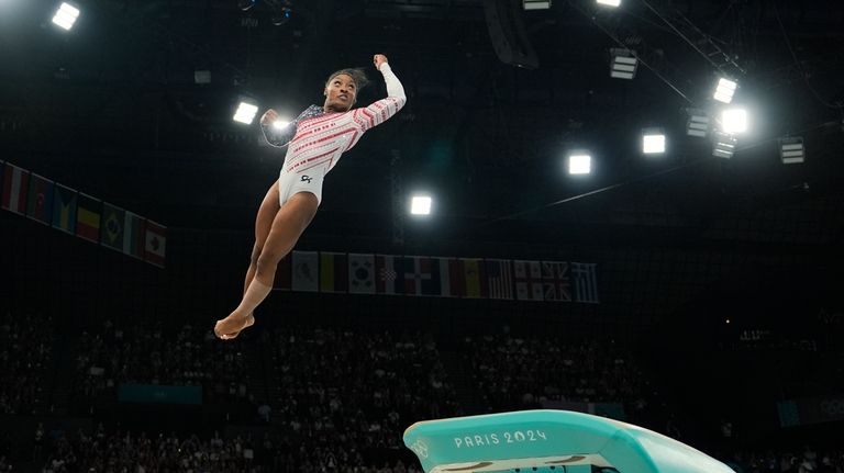 Simone Biles, of the United States, performs on the vault...