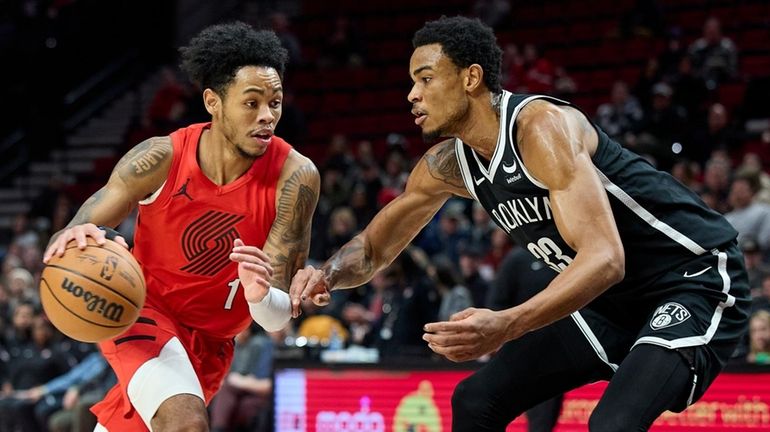 Trail Blazers guard Anfernee Simons, left, drives against Nets center...