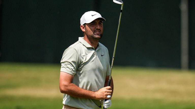 Scottie Scheffler watches his ball on the first fairway during...