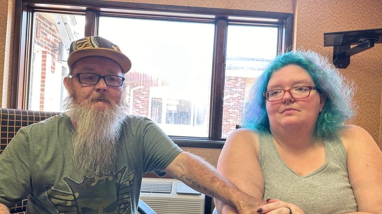 Bruce and Nova Jewett, who are experiencing homelessness, sit at...