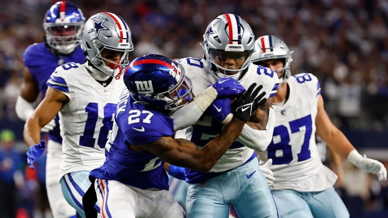 Cowboys running back Tony Pollard, center, is tackled by Giants safety...