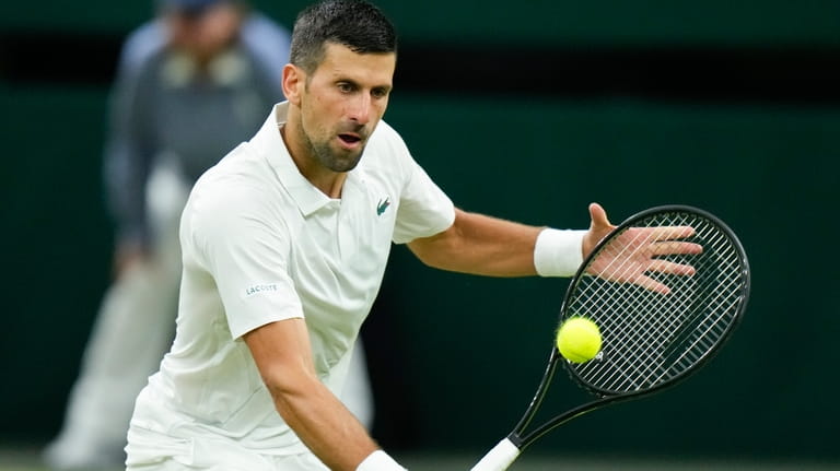 Novak Djokovic of Serbia plays a backhand return to Holger...