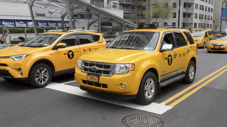 Yellow cabs travel along East 86th Street in Manhattan in...