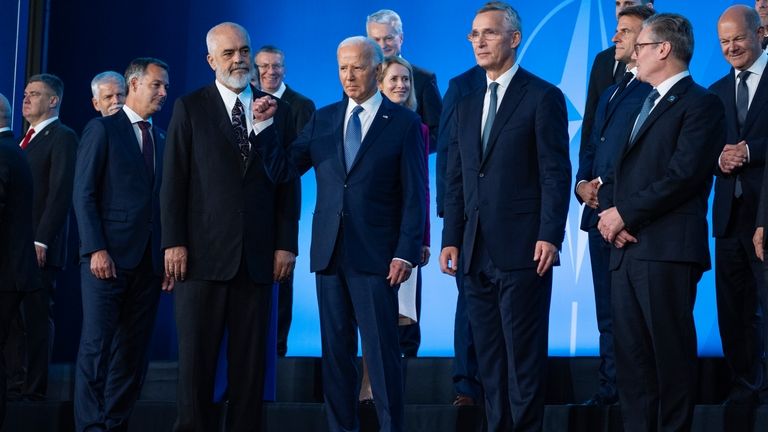 President Joe Biden pumps his fist during a family photo...