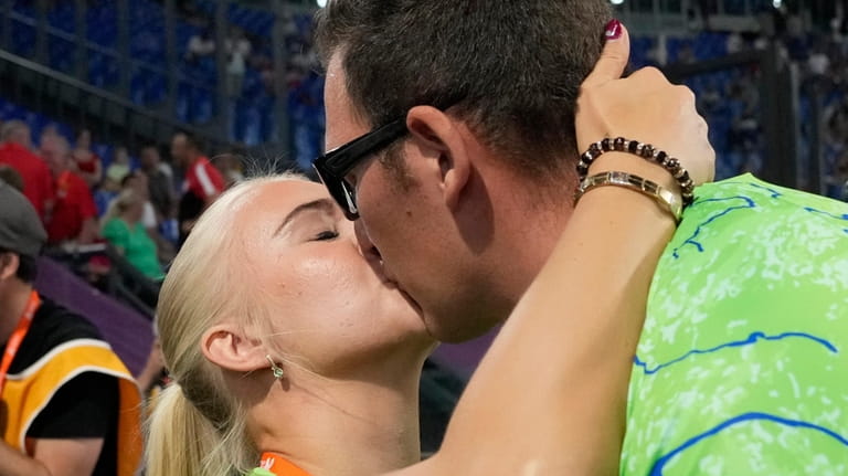 Kristjan Ceh, of Slovenia, gets a kiss after winning the...