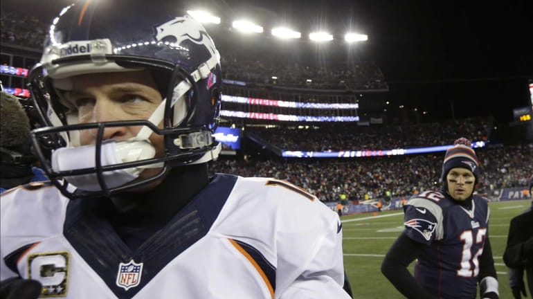 Peyton Manning walks away from Tom Brady after the Patriots...