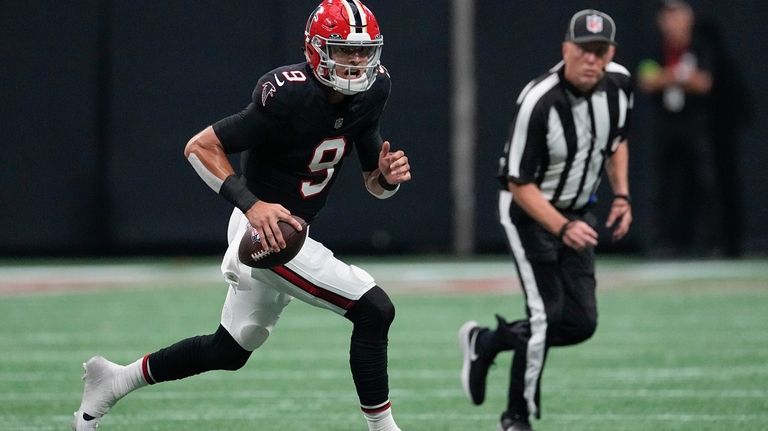 Atlanta Falcons quarterback Desmond Ridder (9) runs out of the...