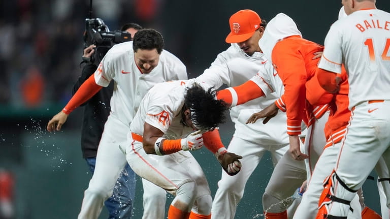 San Francisco Giants' Luis Matos, second from left, is mobbed...