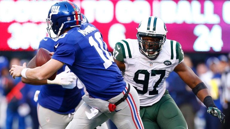 Calvin Pace chases Giants quarterback Eli Manning out of pocket...