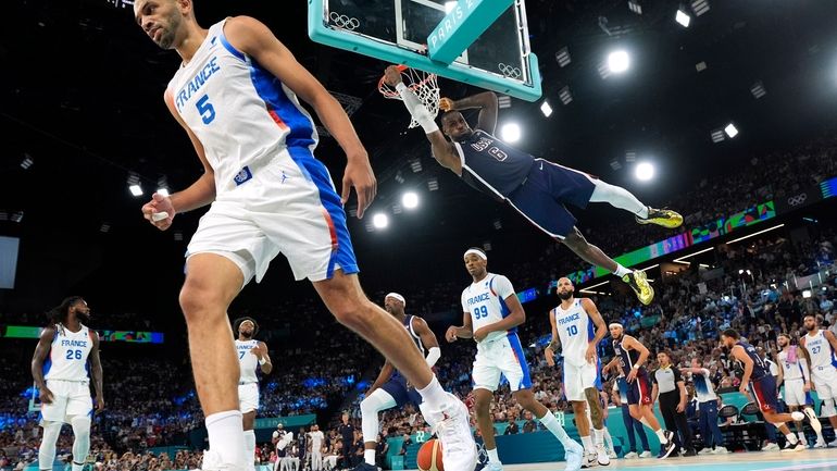 United States' LeBron James, right dunks as France's Nicolas Batum...