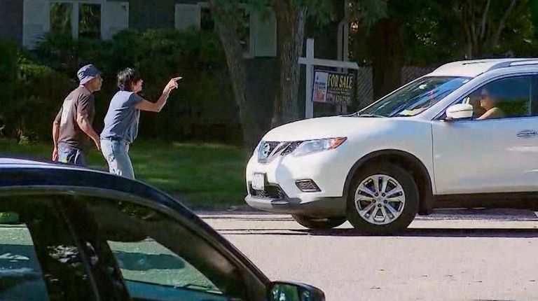 Evelyn Rodriguez, second from left, confronts a motorist on Stahley Street...