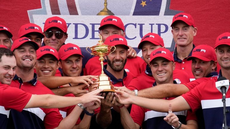 Team USA players and captains pose with the trophy after...