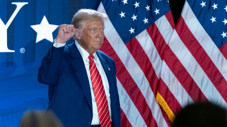 Republican presidential nominee former President Donald Trump gestures as he...