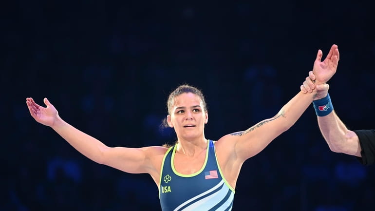 Kayla Miracle raises her arms after winning a 62-kilogram bout...