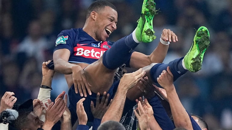PSG's Kylian Mbappe is tossed into the air as he...