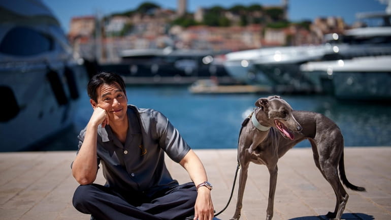 Eddie Peng poses with his dog Xin during an interview...