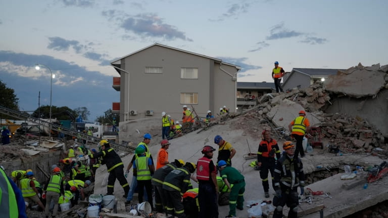 Emergency workers on the scene of a building collapse in...