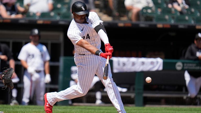 Chicago White Sox designated hitter Eloy Jiménez hits a single...