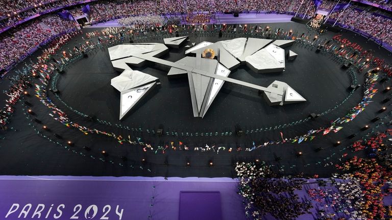 Flag bearers surround the stage during the 2024 Summer Olympics...