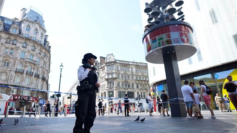 A Police officer stands at the scene in Leicester Square,...