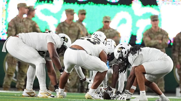 Colorado wide receiver Travis Hunter, back center, spins the ball...