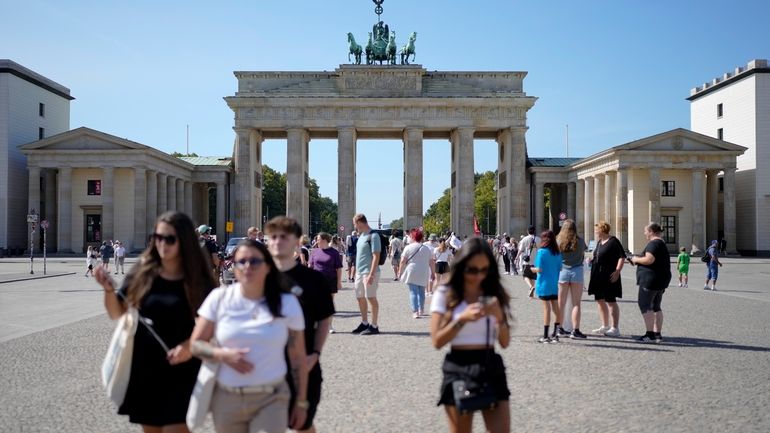 People stand in front of Berlin's famous landmark 'Brandenburg Gate'...