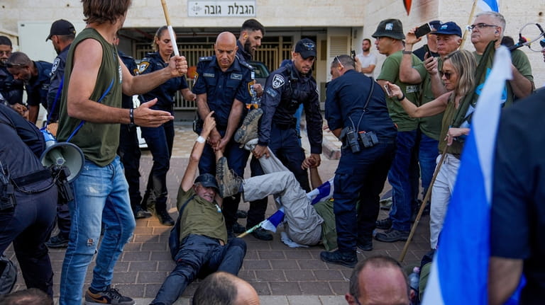 Israeli police disperse demonstrators, mostly military reservists, who block a...