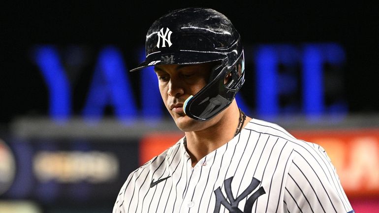 Yankees designated hitter Giancarlo Stanton returns to the dugout after...