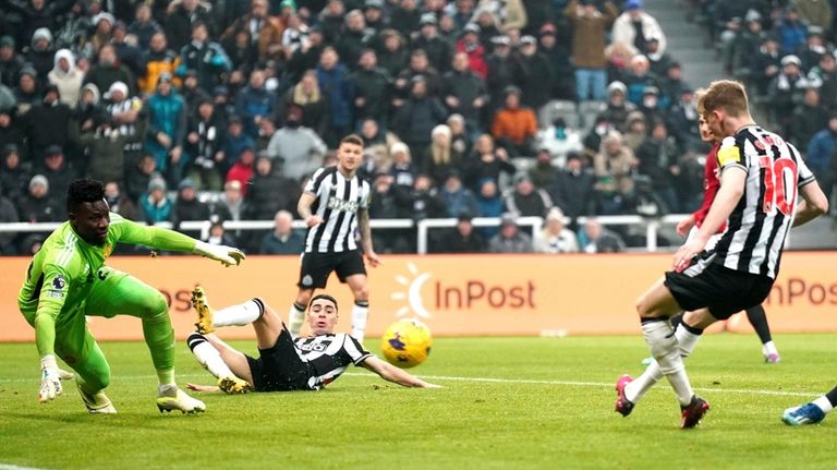 Newcastle United's Anthony Gordon, right, scores a goal during the...