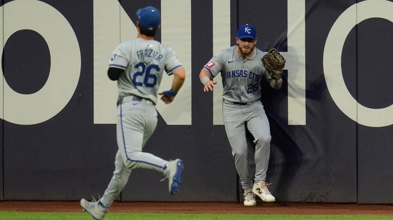 Kansas City Royals center fielder Kyle Isbel (28) crashes into...