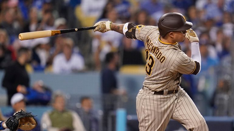 FILE - San Diego Padres' Manny Machado follows through on...