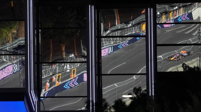 Red Bull driver Sergio Perez, of Mexico, is reflected into...