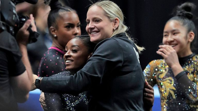 Simone Biles gets a hug from her coach Cecile Landi...