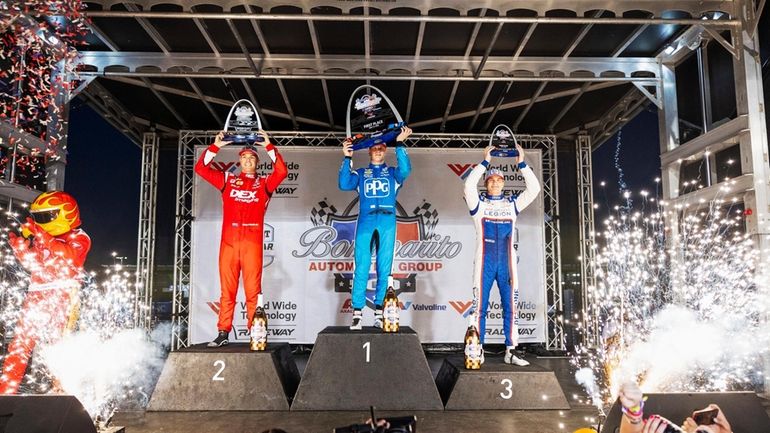 From left, Scott McLaughlin, Josef Newgarden, and Marcus Armstrong hold...