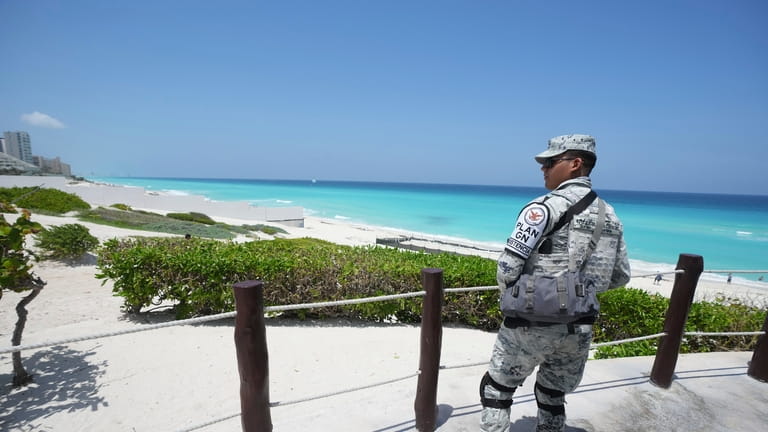A Mexican soldier stands guard on a beach ahead of...
