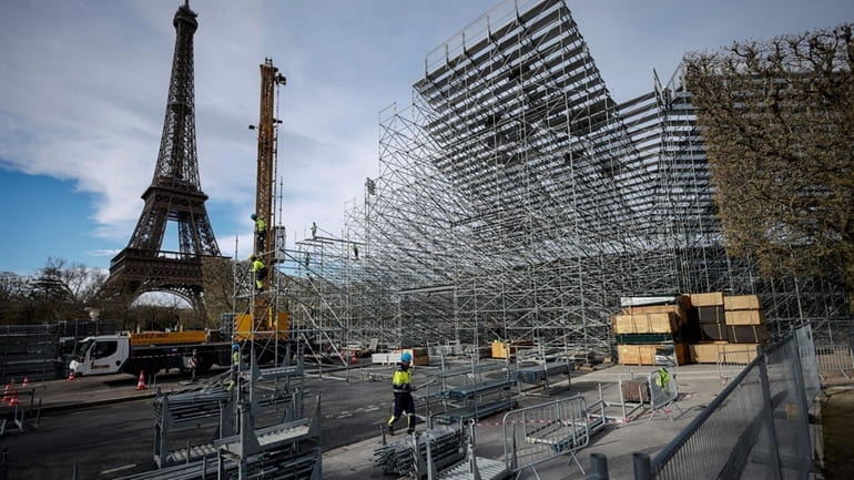 Workers build the stands for the upcoming Olympic Games on...