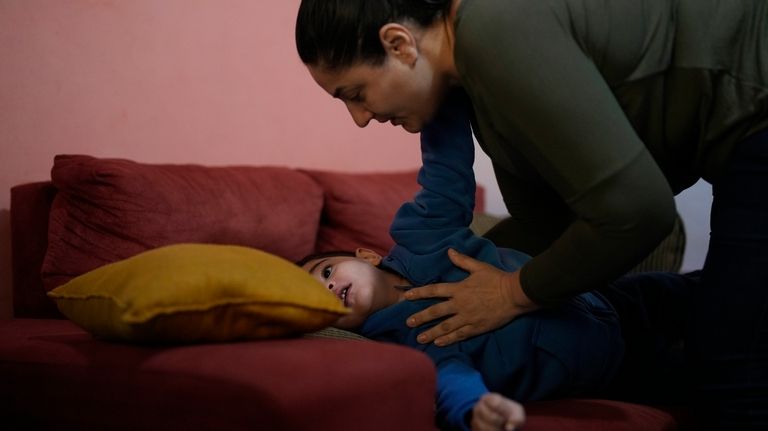 Janaina Silva tends to her four-year-old son Murillo during an...