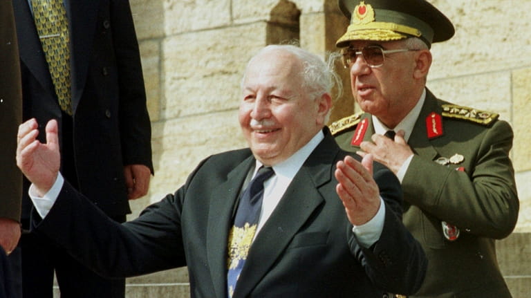 Turkish then-Prime Minister Necmettin Erbakan greets generals after laying a...