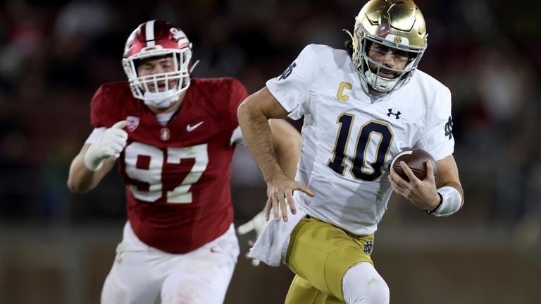 Notre Dame quarterback Sam Hartman (10) runs as Stanford defensive...