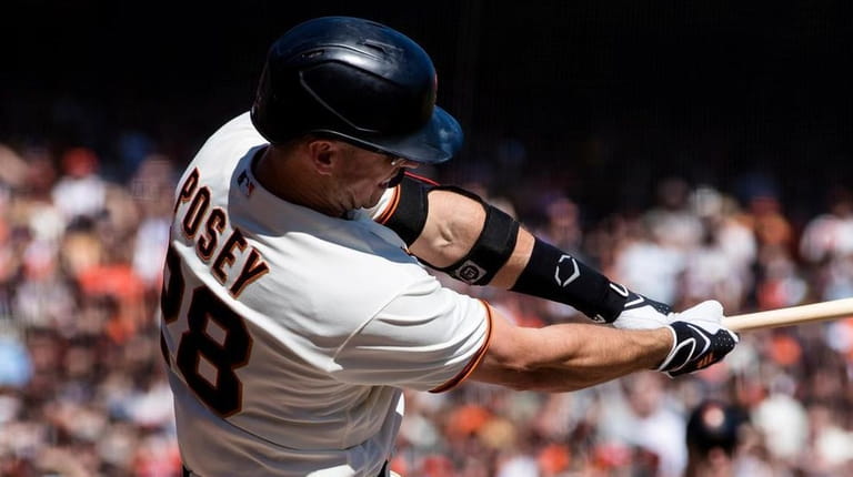 The Giants' Buster Posey hits a two-run single against the...