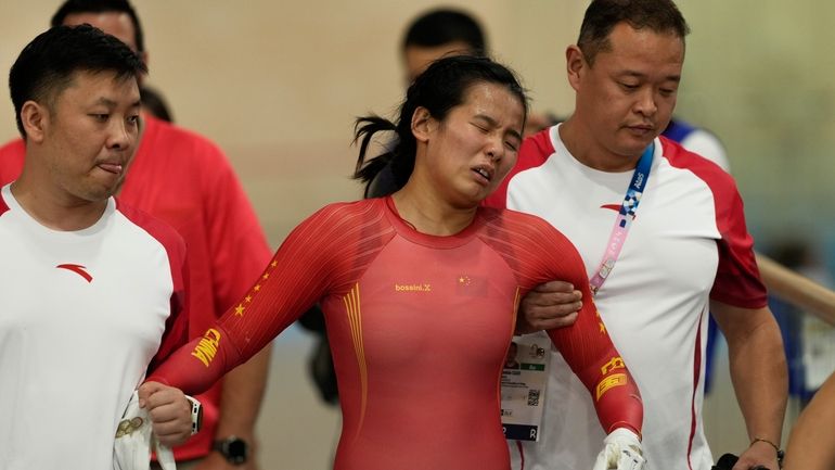 Liying Yuan of China is assisted after crashing during the...