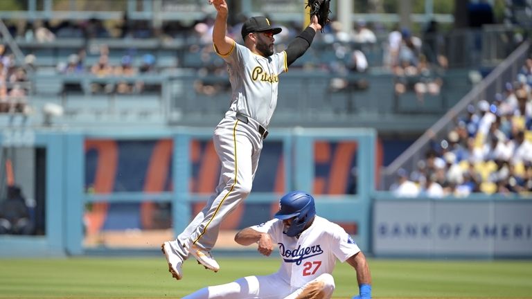 Los Angeles Dodgers' Amed Rosario (27) slides under a high...