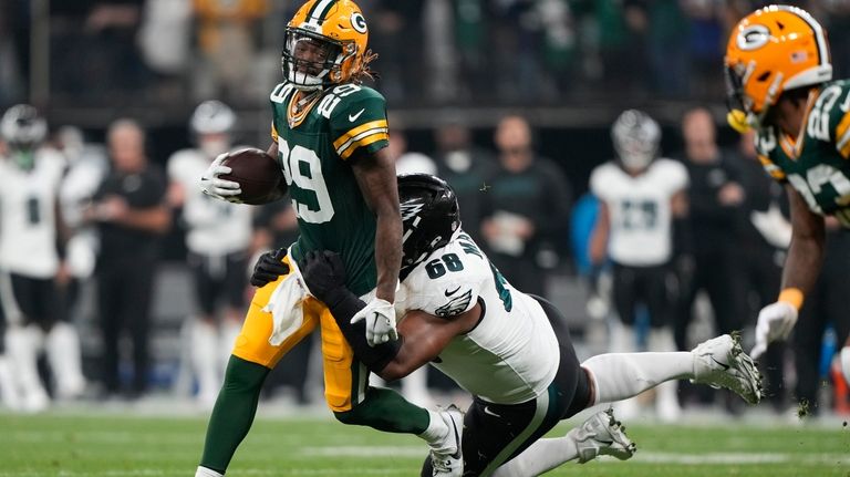 Green Bay Packers safety Xavier McKinney (29) is tackled by...